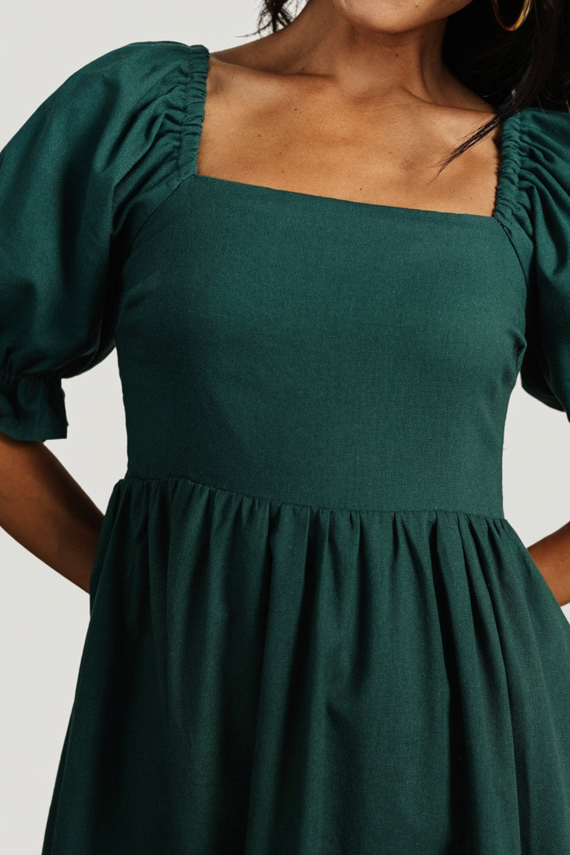 Close-up of mid-length sleeve with elastic and ruffle cuff on Evergreen smocked midi dress, highlighting fabric texture and sleeve silhouette.