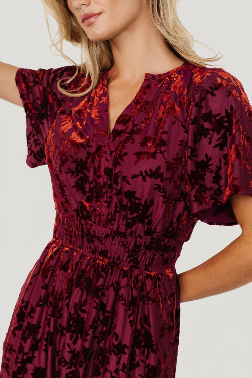 Back view of Bronwyn velvet midi dress in rust showing gathered bodice, smocked waistband and the fall of the two-tier skirt for movement.