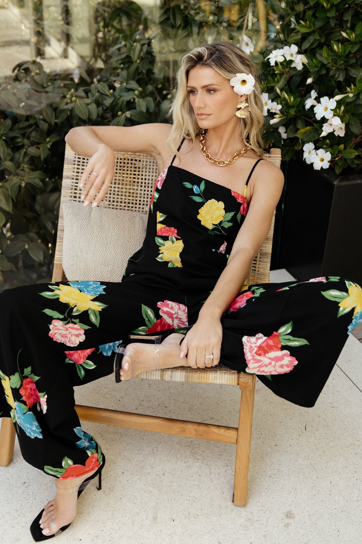 Styled look: black floral jumpsuit paired with neutral heels, emphasizing its versatile high waist, wide legs and elegant printed chiffon.