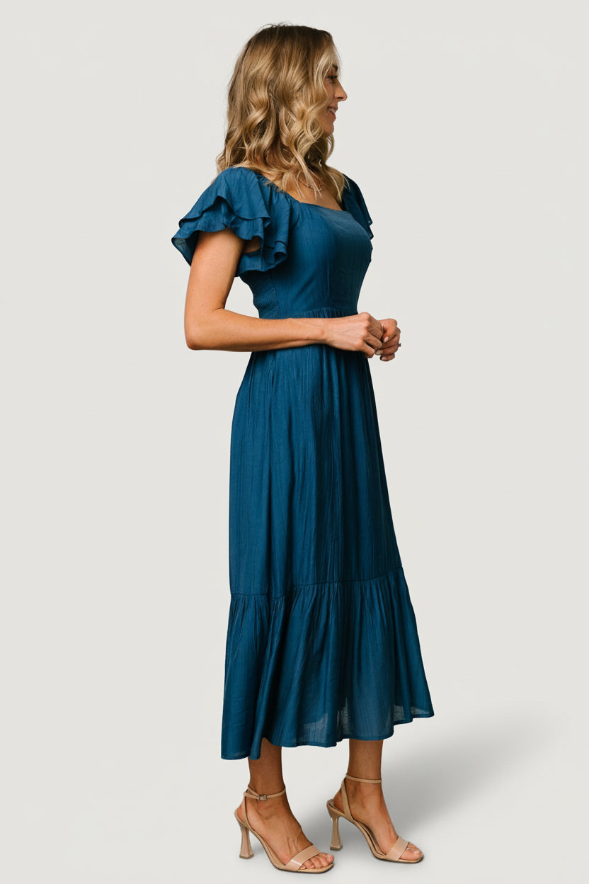 Close-up of soft textured woven fabric and lined bodice in deep blue, emphasizing subtle texture and construction.