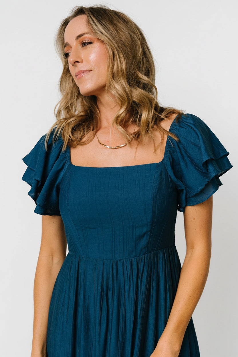 Three-quarter view showing smocked back bodice and elastic at the shoulders, highlighting comfortable stretch and back detailing.