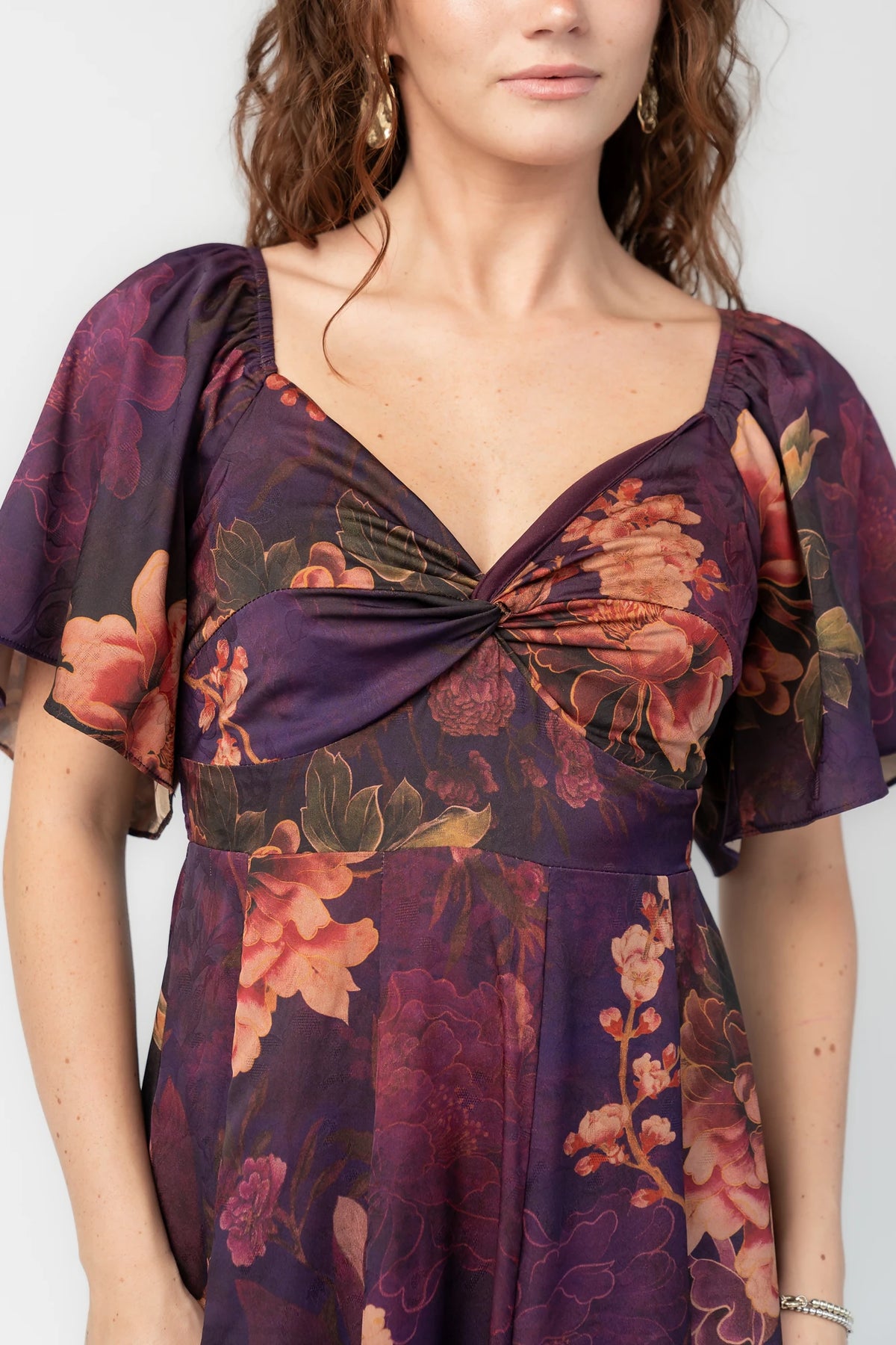 Caterina Maxi Dress in Purple Floral with knotted sweetheart neckline, flutter sleeves, smocked back, and godet skirt.