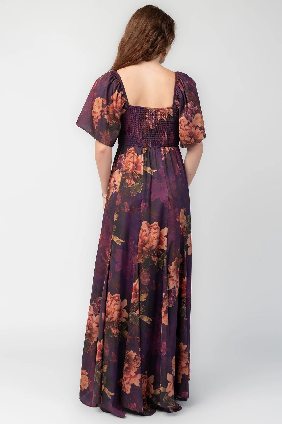 Caterina Maxi Dress in Purple Floral with knotted sweetheart neckline, flutter sleeves, smocked back, and godet skirt.