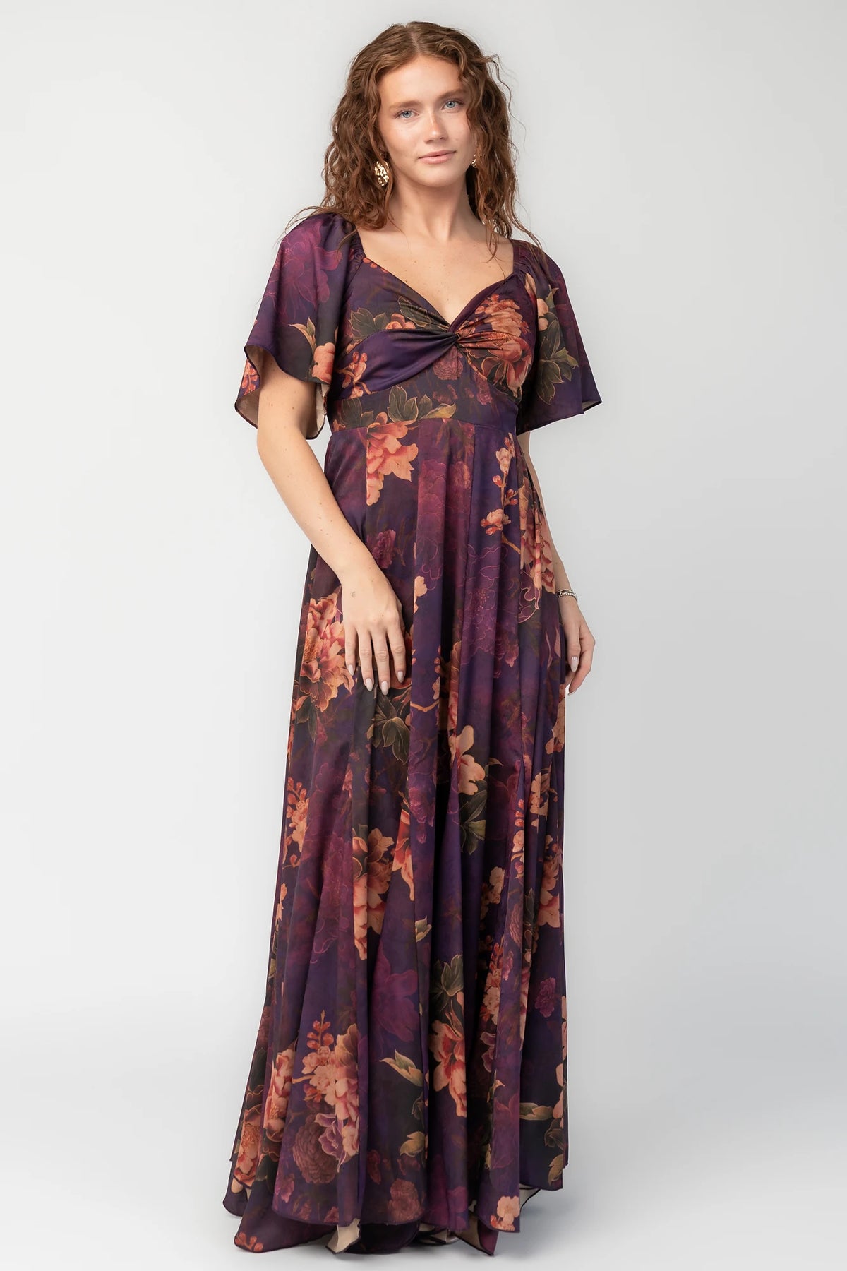 Caterina Maxi Dress in Purple Floral with knotted sweetheart neckline, flutter sleeves, smocked back, and godet skirt.