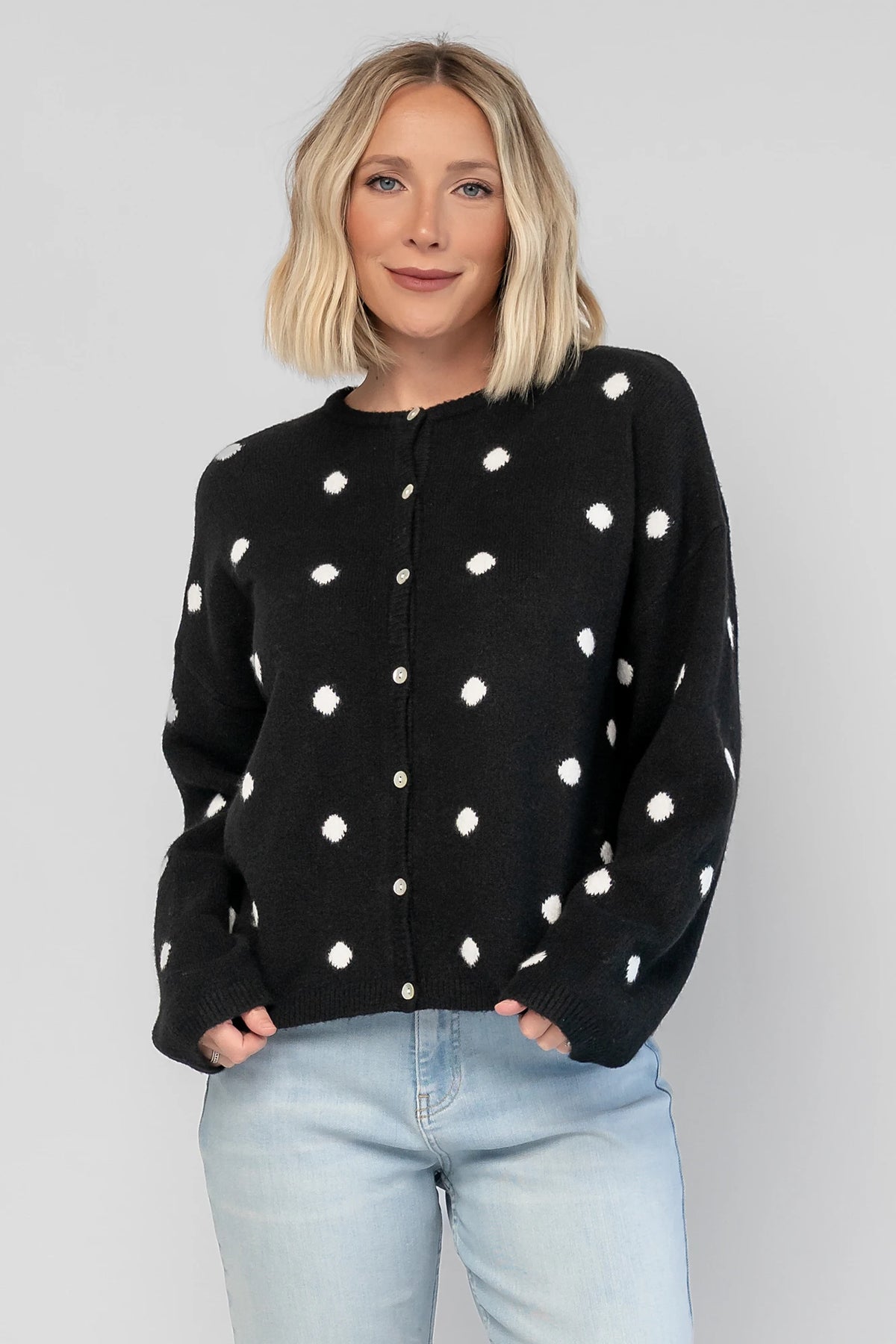 Cinder Cardigan in Black + White Dot with a button-front closure, polka-dot trim, and a relaxed knit silhouette.