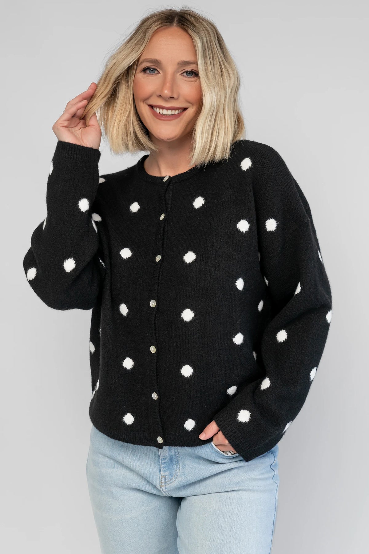 Cinder Cardigan in Black + White Dot with a button-front closure, polka-dot trim, and a relaxed knit silhouette.