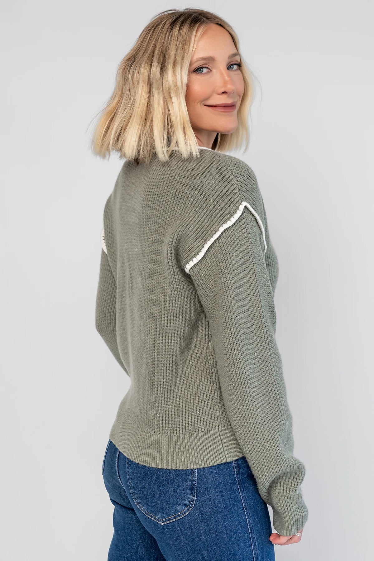 Clarke Button Up Cardigan in Dusty Sage with tortoise-colored buttons, white piping details, and a button-front design.