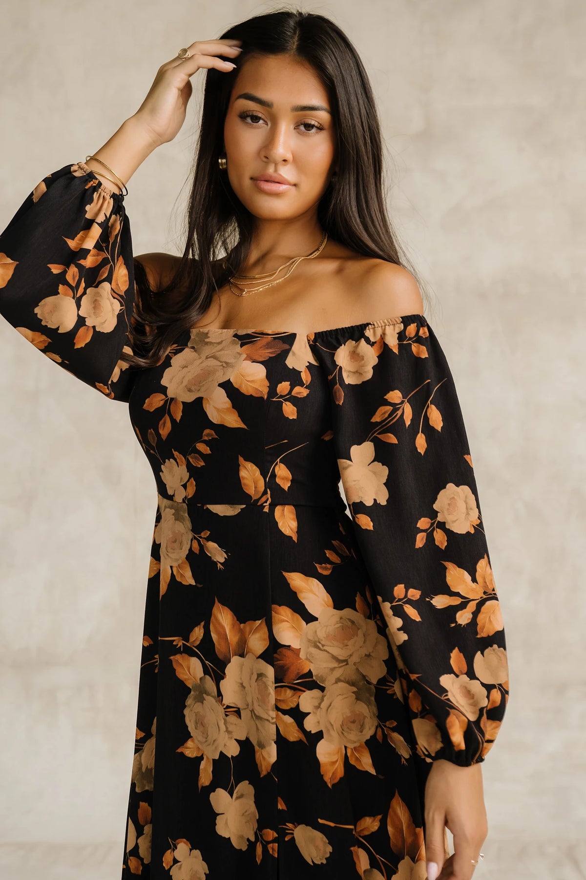 Cordelia Off Shoulder Maxi Dress in Black + Gold Floral with an off-shoulder neckline, billowy sleeves, and a leg slit.