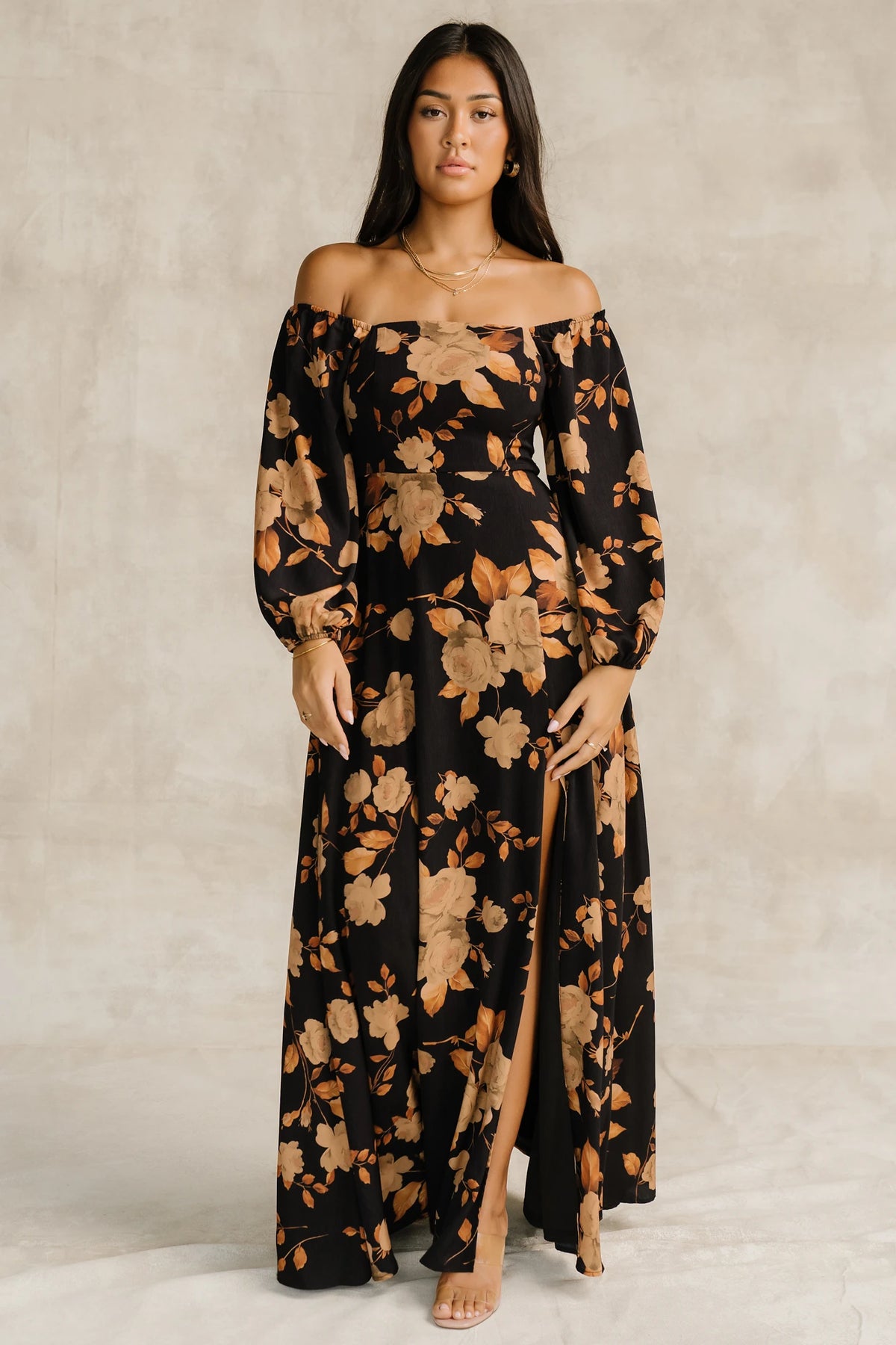 Cordelia Off Shoulder Maxi Dress in Black + Gold Floral with an off-shoulder neckline, billowy sleeves, and a leg slit.