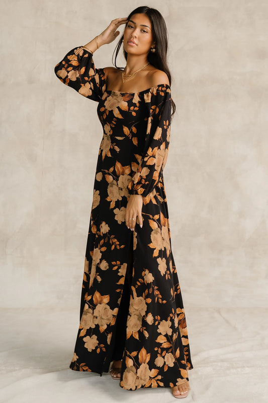 Cordelia Off Shoulder Maxi Dress in Black + Gold Floral with an off-shoulder neckline, billowy sleeves, and a leg slit.