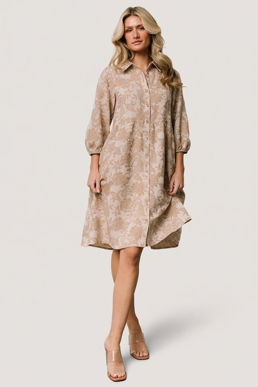 Front view of Dakota Babydoll Dress in taupe botanical print on model, showing button-front, collar, and tiered short skirt.
