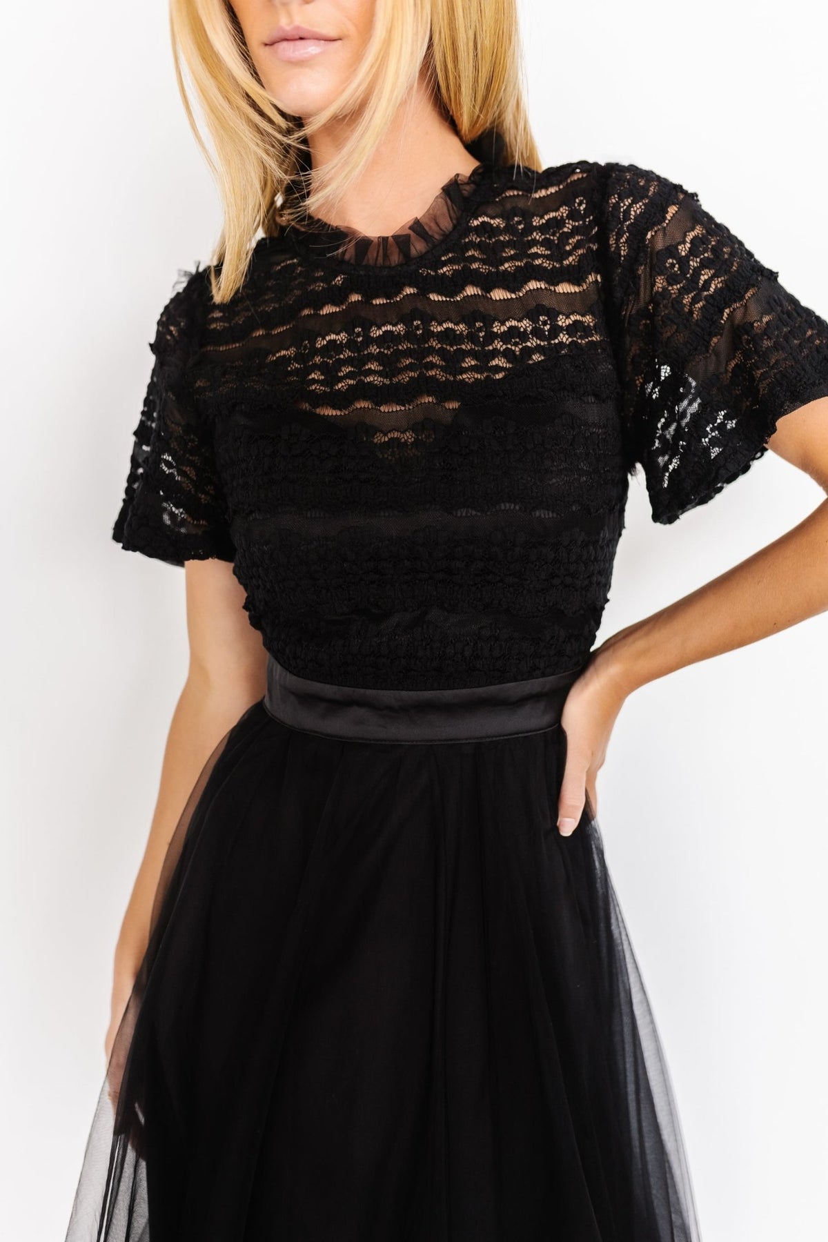 Close-up of lace bodice and satin waist tie, highlighting texture, stitch detail, and the lined sweetheart inner shape of the dress.