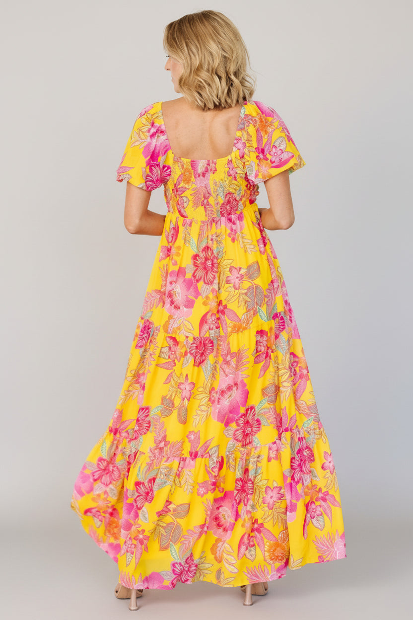 Side view of yellow and pink floral chiffon maxi showing empire waistline and the flowing tri-tiered skirt movement.