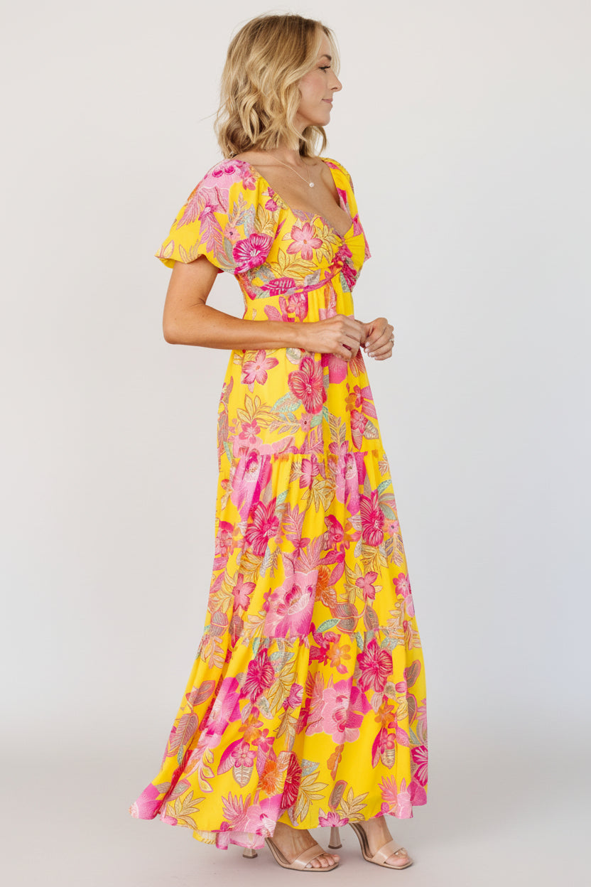 Back view of the Darla maxi dress displaying tiered skirt and lightweight chiffon fabric with lined body and sheer sleeves.