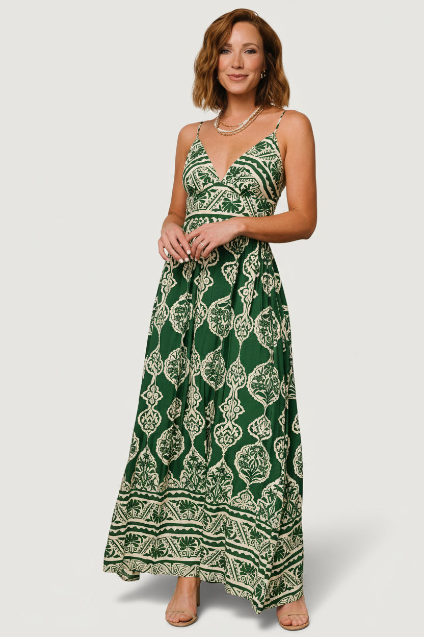 Front three-quarter shot of the green printed V-neck maxi dress highlighting the gathered bust, up-pointed waist panel and print placement.