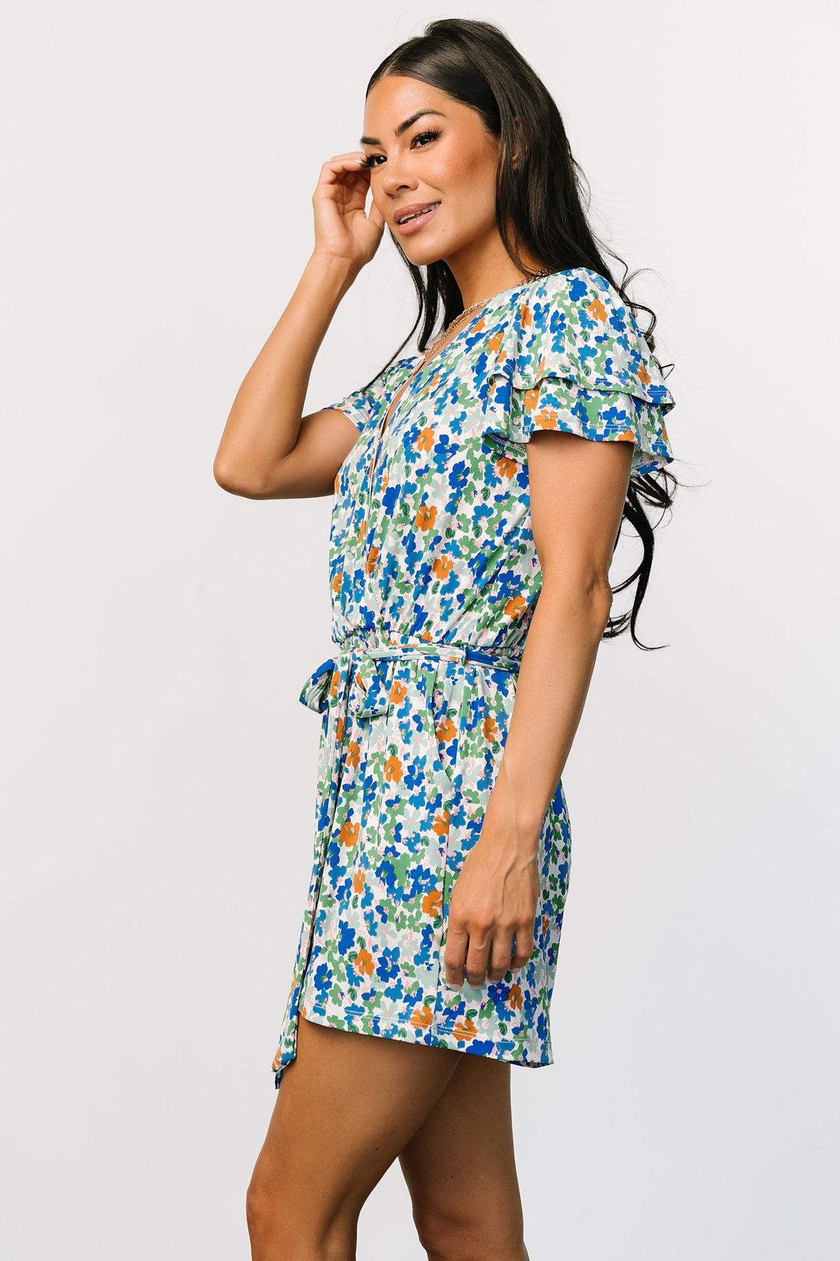 Styled shot of the romper paired with sandals, showing overall silhouette, surplice neckline, and how the elastic waist shapes the fit.
