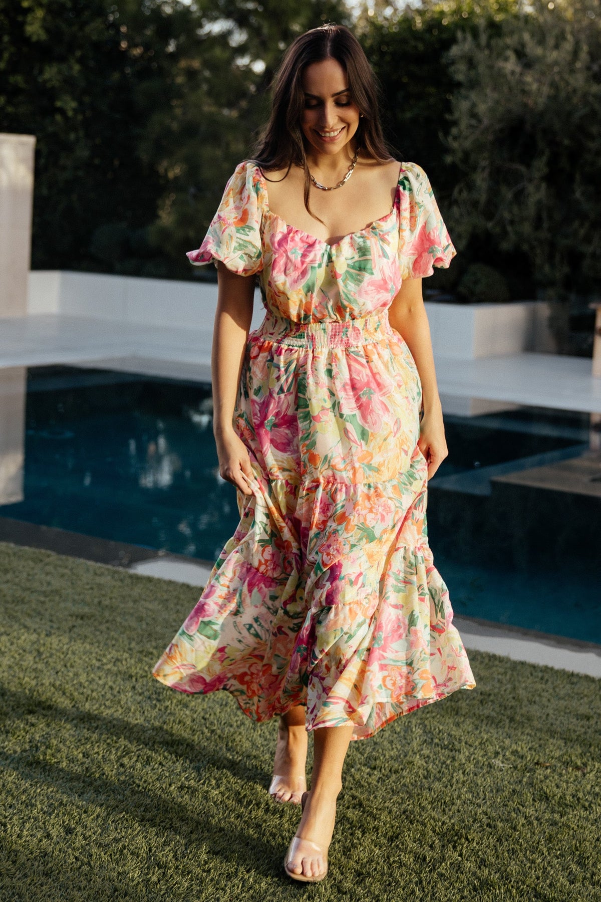 Styled outfit shot of the multi floral midi dress on a neutral backdrop highlighting overall fit, vibrant colors and feminine silhouette.