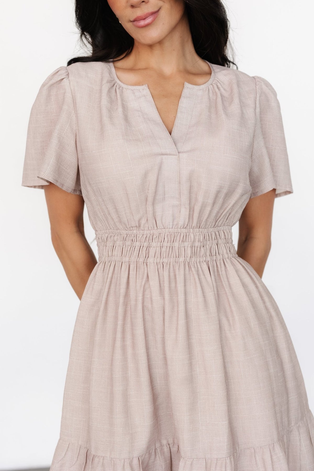 Back view of Dita short dress in natural check, displaying the fully lined bodice and skirt, and the sheer flutter sleeves left unlined.