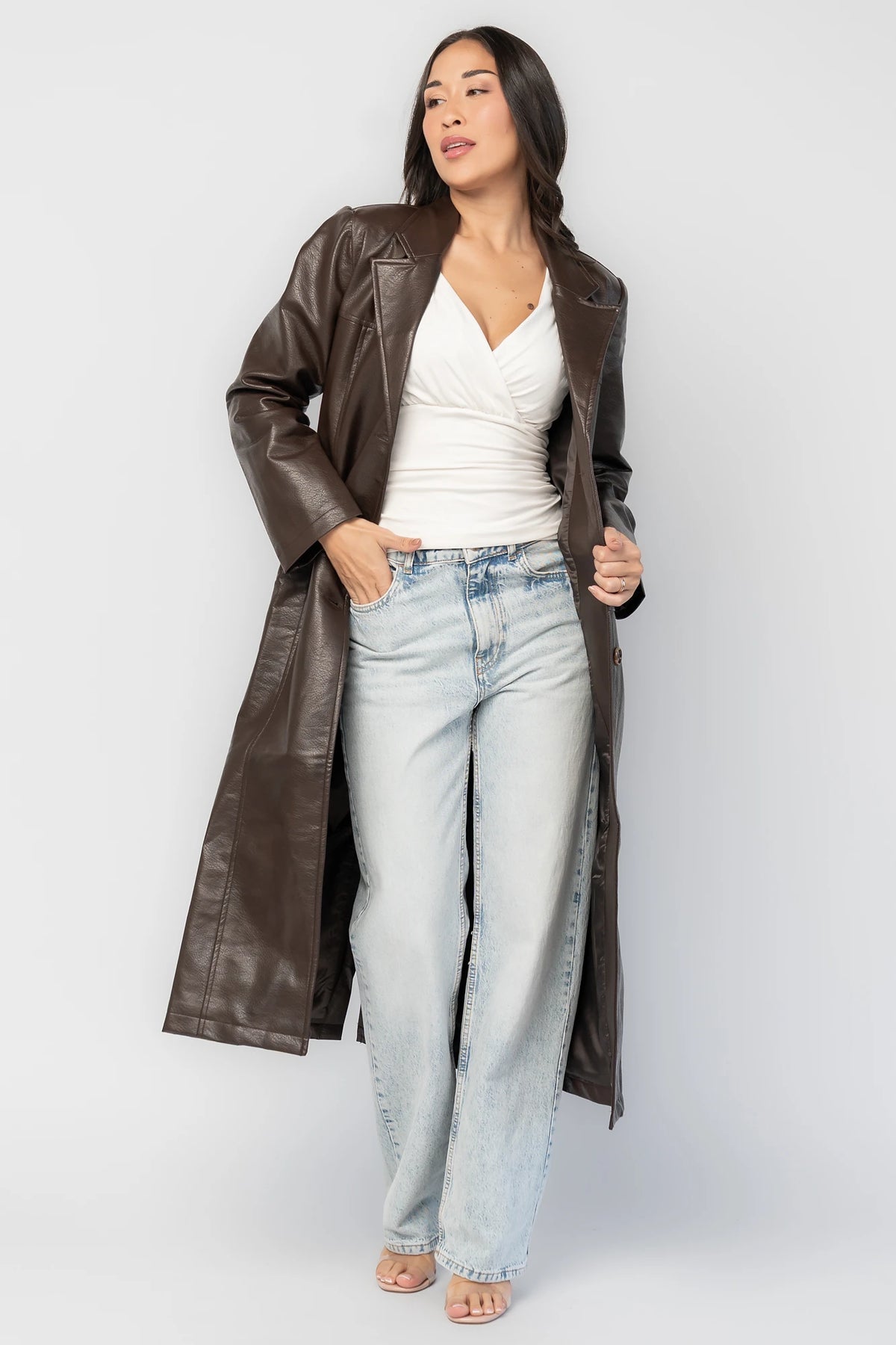 Dove Coat in Brown Faux Leather with notched collar, button front, long sleeves, patch pockets, and longline silhouette.