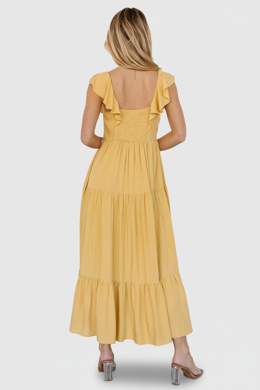 Model walking in golden yellow dress to show skirt drape, movement of tiers, and placement of hidden side pockets in action.