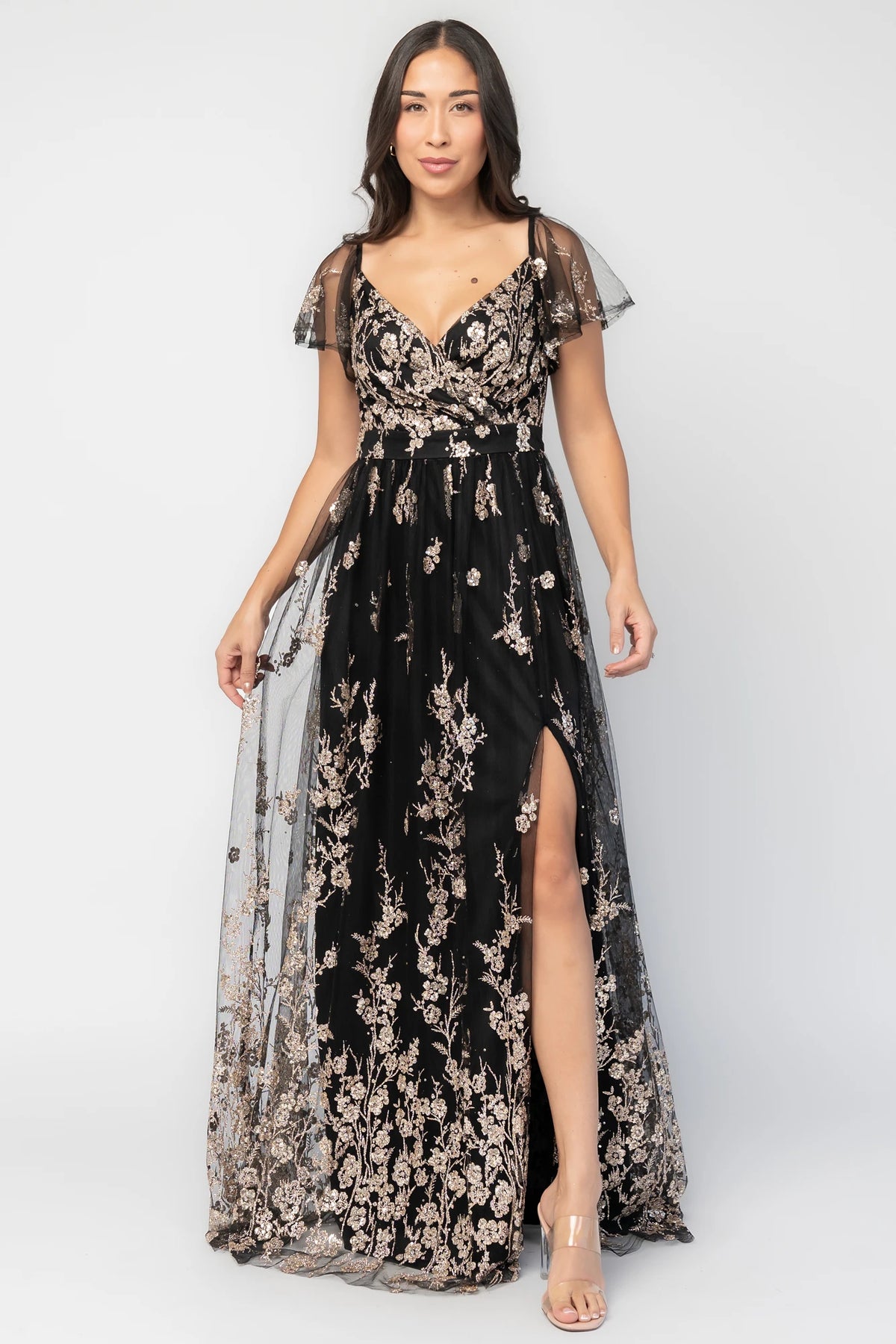 Esmerelda Shimmer Gown in Black + Rose with floral sequin embroidery, surplice V-neckline, flutter sleeves, and front slit.