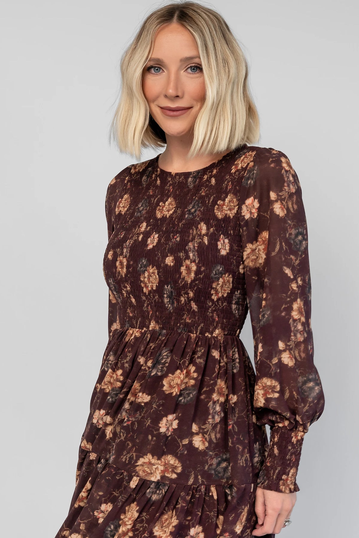 Evelyn Smocked Midi Dress in Dark Clove Floral with a smocked bodice, smocked cuffs, and a tiered midi skirt.