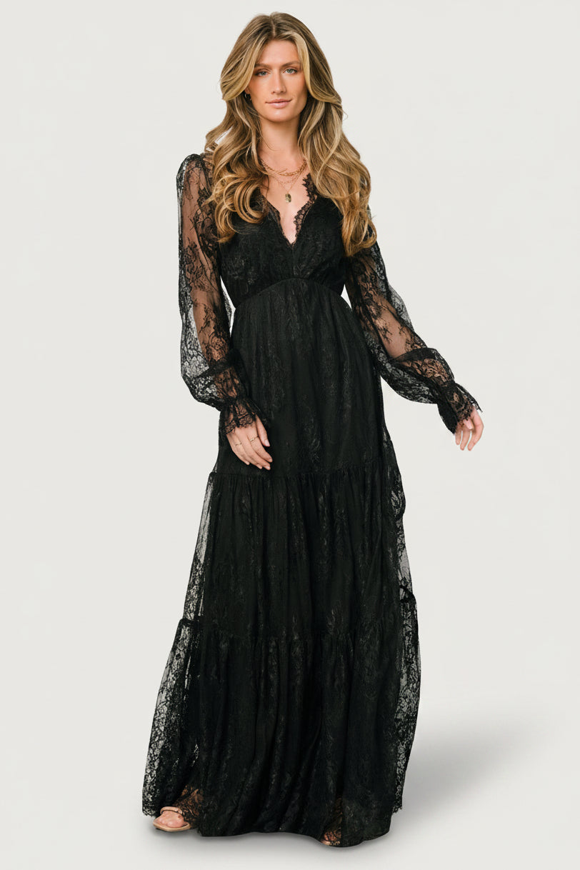 Gloria Lace Maxi Dress in Black with deep V-neck, sheer long sleeves, elastic waist, and three-tiered lace skirt.