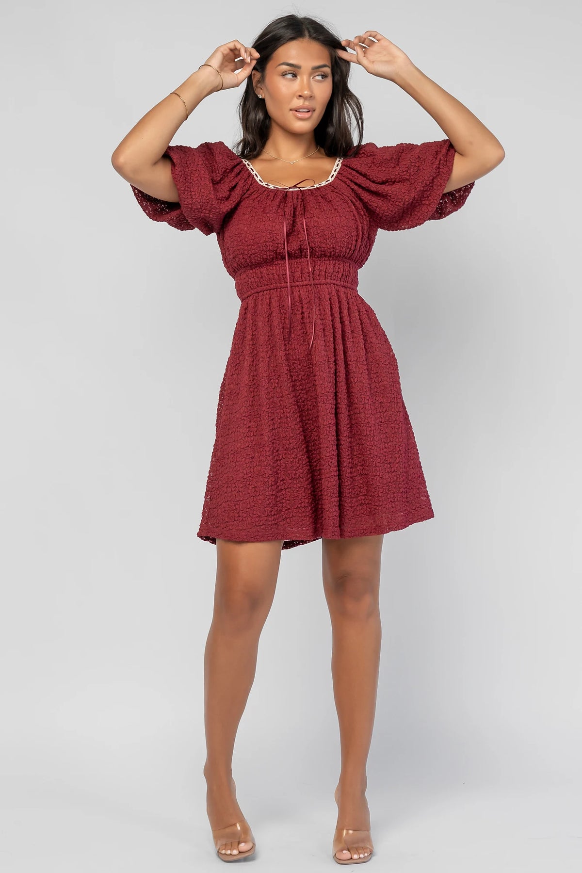 Gwyneth Short Dress in Burgundy with textured floral lace, scoop neckline, cream lace piping, and elastic sleeve cuffs.