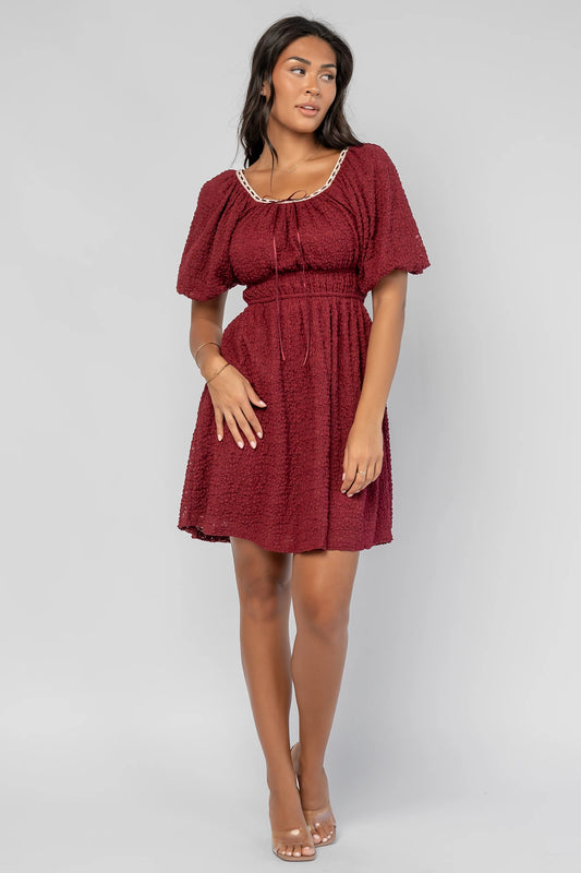 Gwyneth Short Dress in Burgundy with textured floral lace, scoop neckline, cream lace piping, and elastic sleeve cuffs.