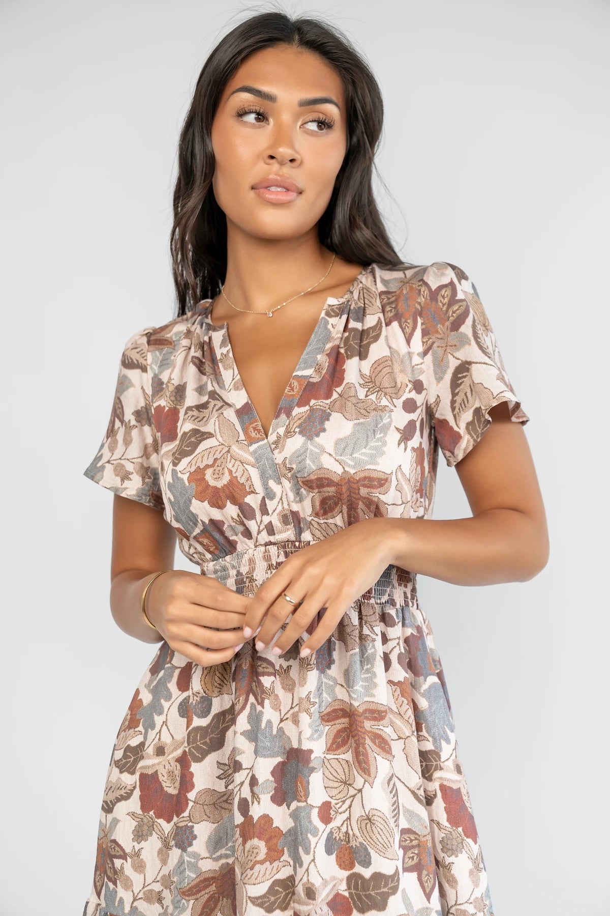 Holland Dress in Taupe Multi with a smocked waist, V-neckline, flutter sleeves, and a floral print.