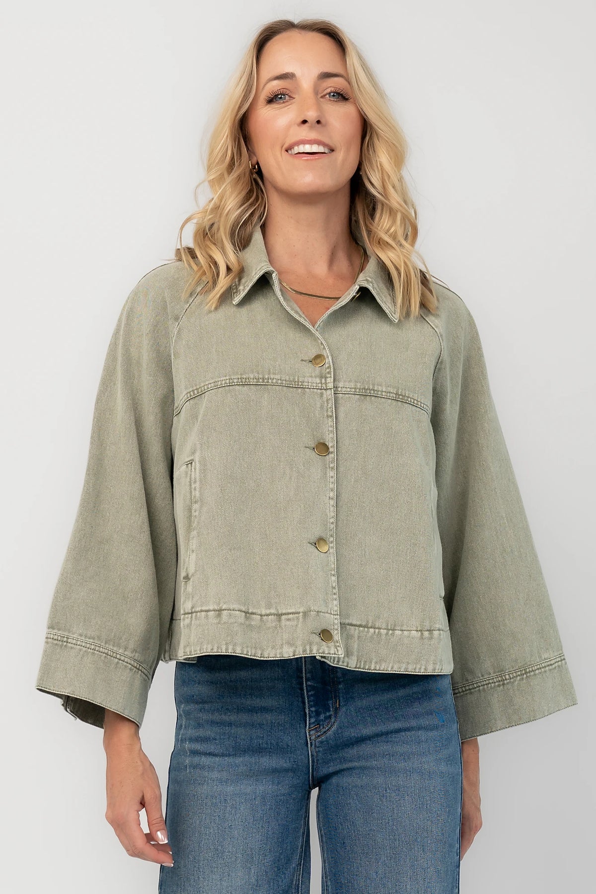 Dusty Olive Cropped Cotton Jacket with collared neckline, button front, raglan sleeves, adjustable cuffs, and side pockets.