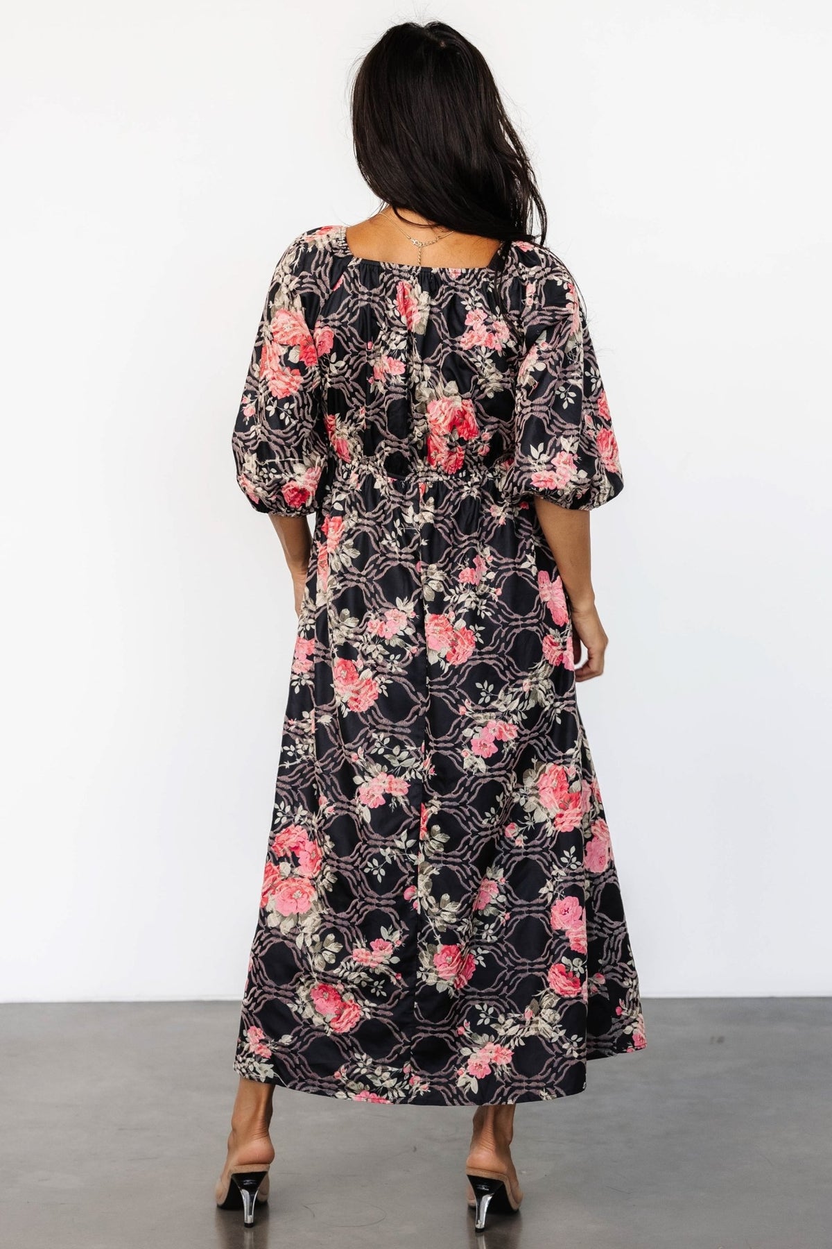 Detail of puffed 3/4 sleeve with elastic at the shoulder showing unlined drape and embroidered floral motif near cuff.
