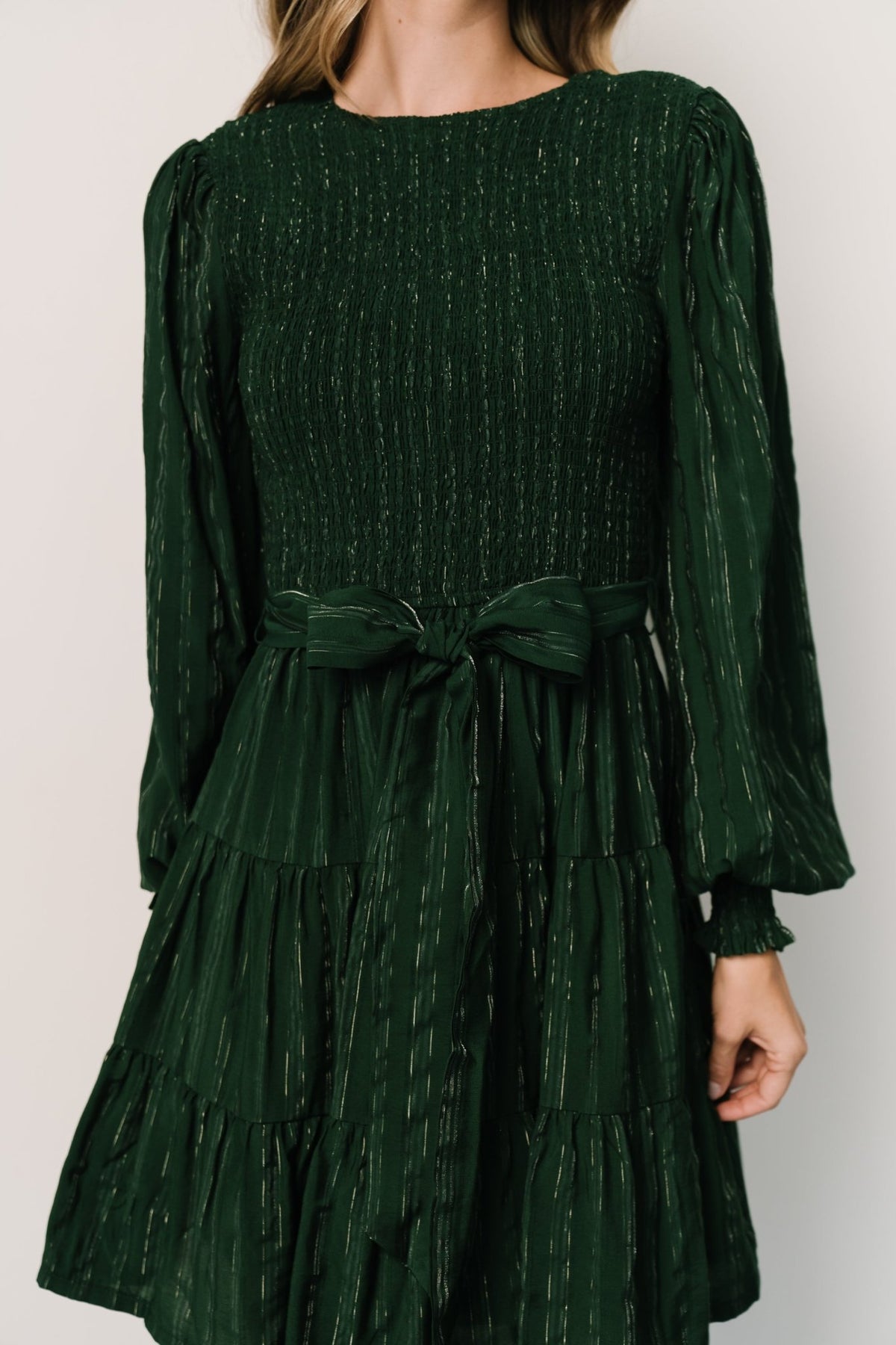 Three-quarter view of dress showing tiered short skirt and natural movement of fabric with subtle silver metallic pinstripes throughout.