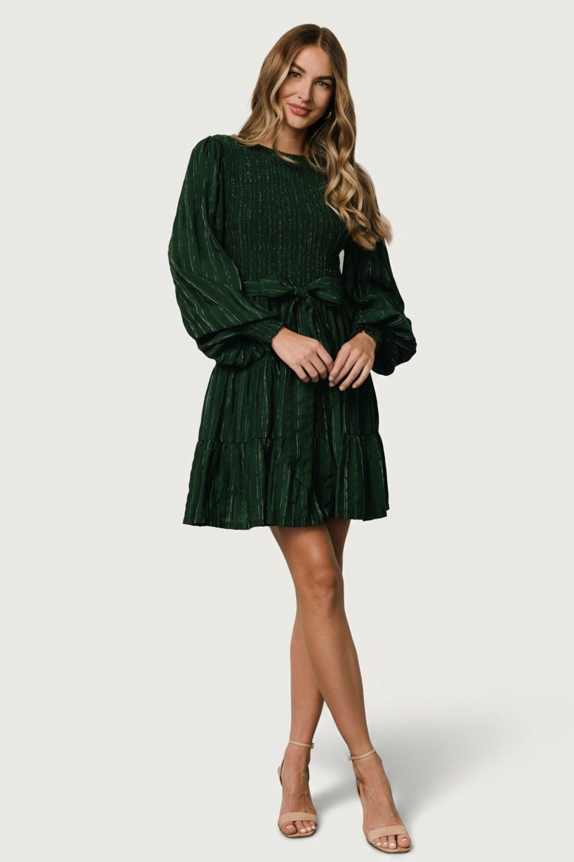 Styled look of Ivey smocked short dress with sash tied at the waist, illustrating fit and proportion on a model for occasion wear.