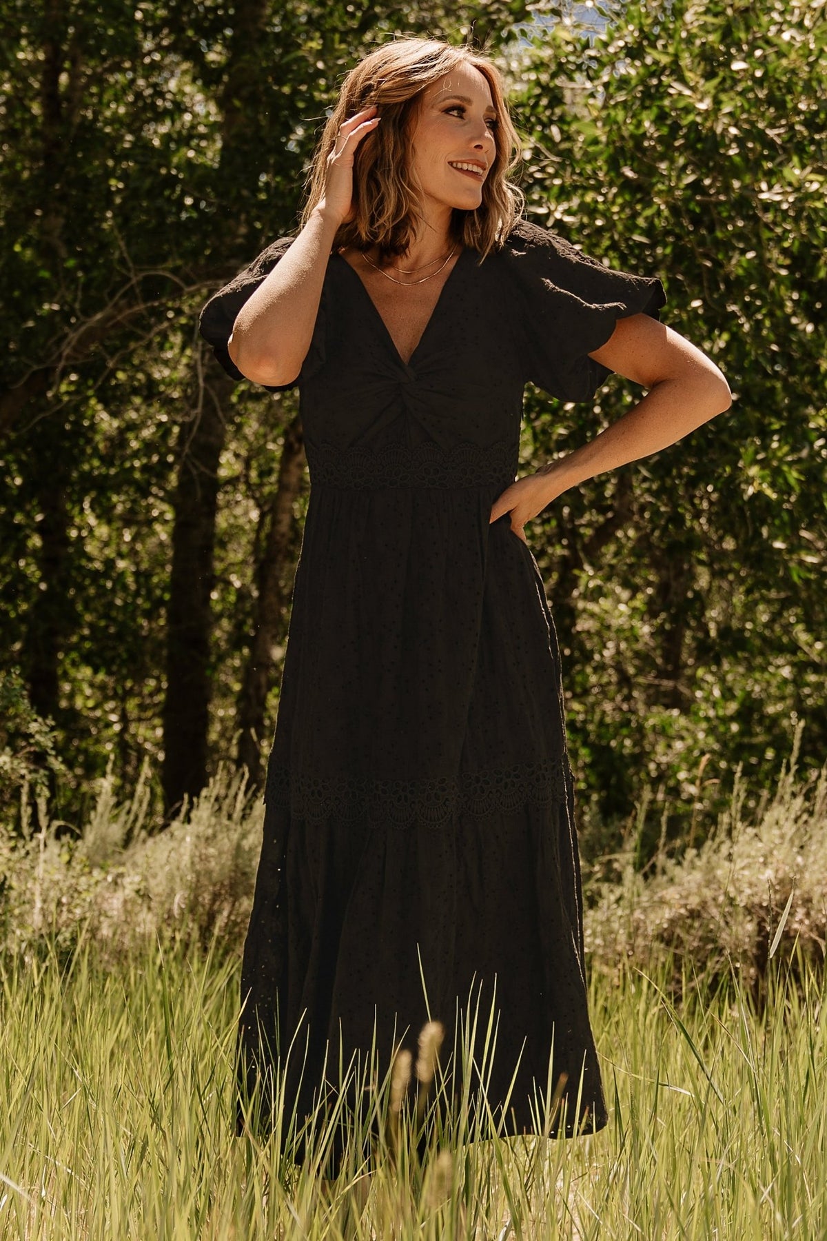 Front view of black Jackie Eyelet Maxi Dress showing V-neck, gathered bust, floral eyelet embroidery and single-tiered maxi skirt with lace trim.