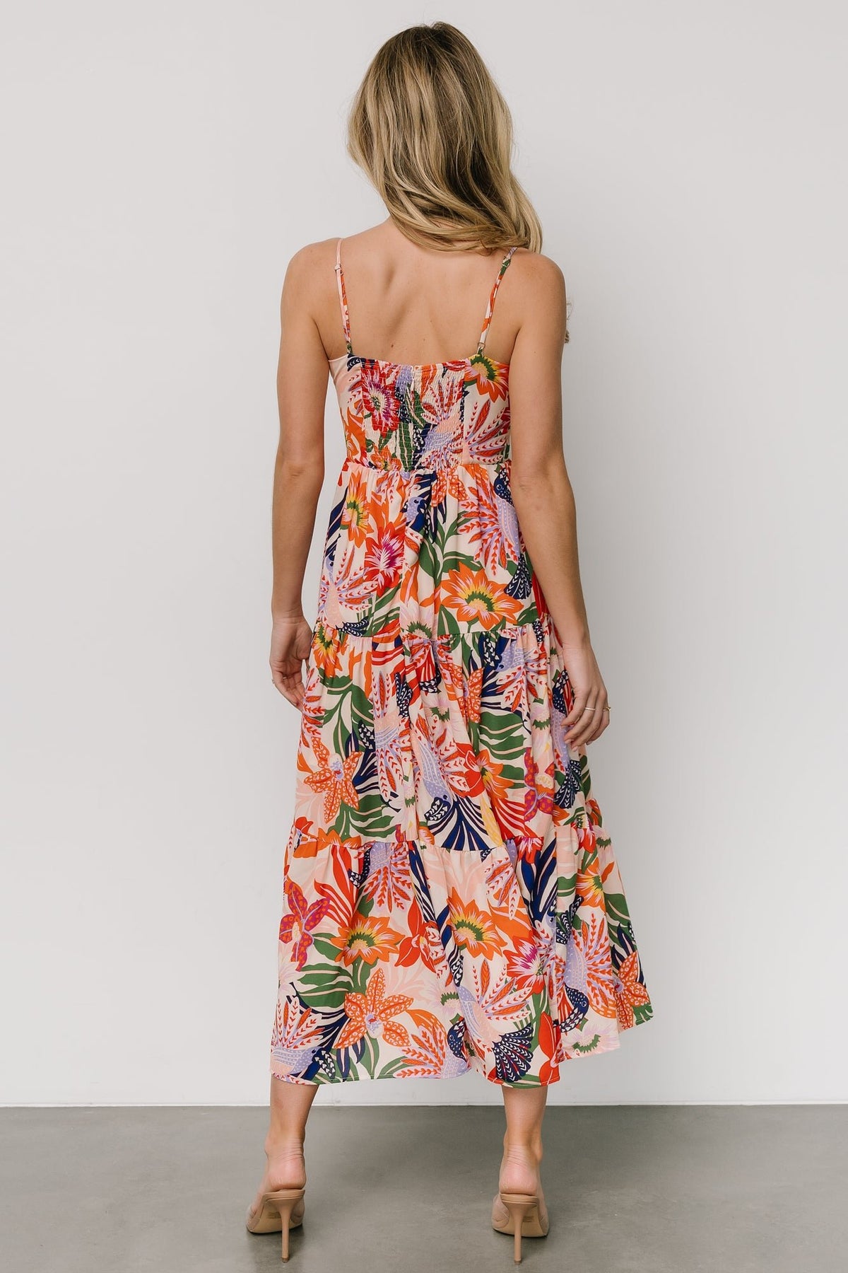 Side view of Jaide midi dress showing tiered skirt movement and colorful botanical and toucan print across the lightweight chiffon fabric.