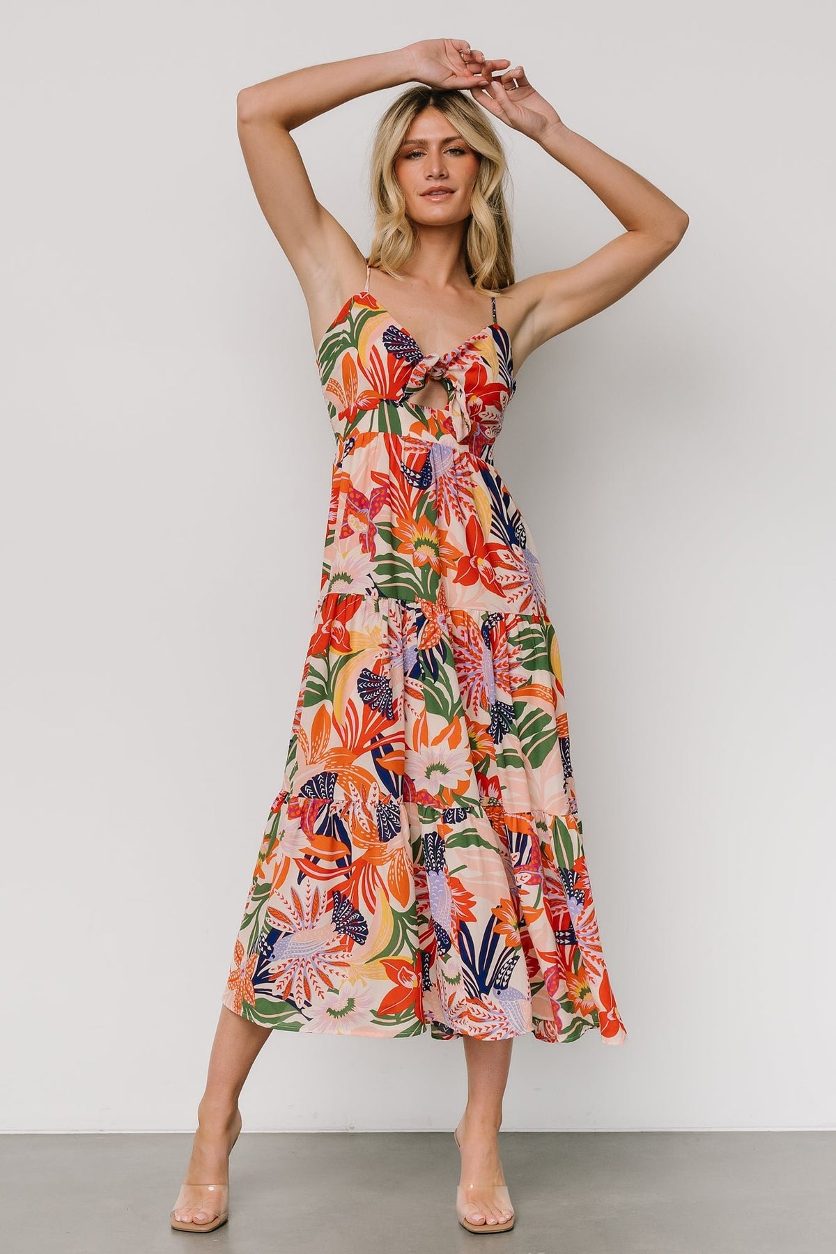 Front view of Jaide midi dress in multi botanical and toucan print, V-neck with adjustable tie, tiered skirt and mid-thigh lining visible.