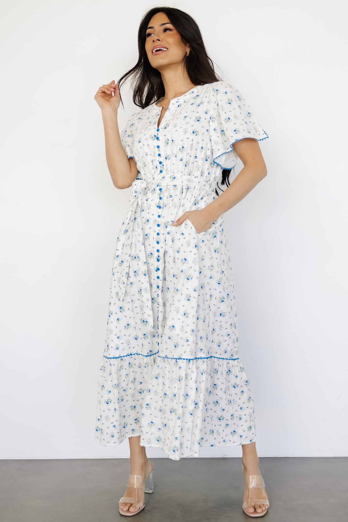 Front view of ivory multi floral Janie midi dress showing V-neckline, lace bodice, functional buttons, and removable sash.
