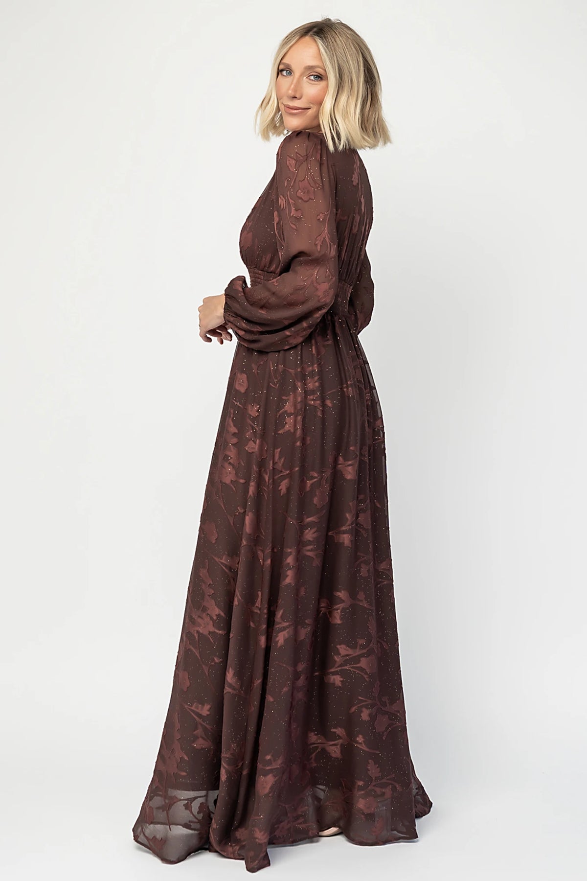 Jennifer Maxi Dress in Dark Mahogany with plunging V-neck, sheer long sleeves, gold sparkle, and textured florals.