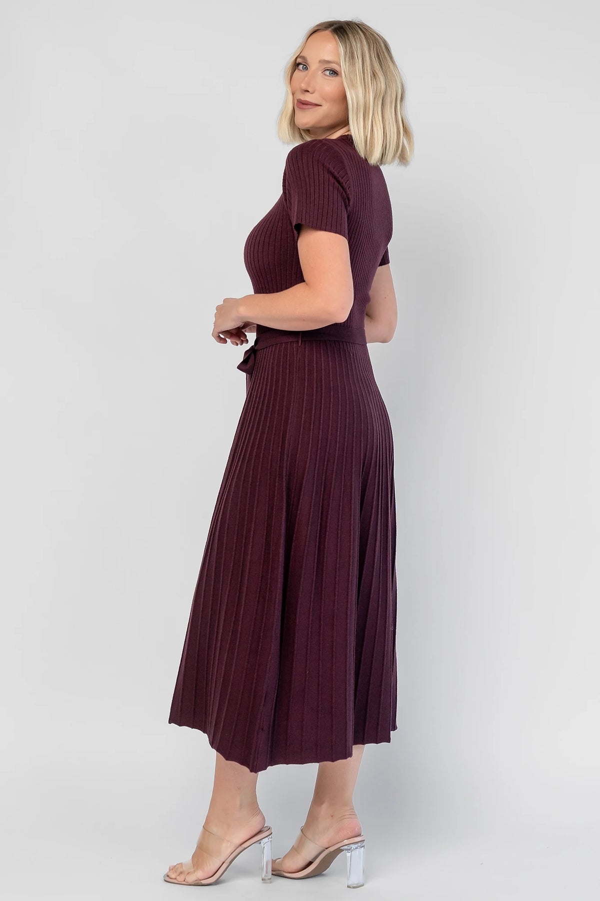 Jessamine Midi Dress in Dark Plum with a ribbed sweater knit, crew neckline, waist belt, and pleated midi skirt.