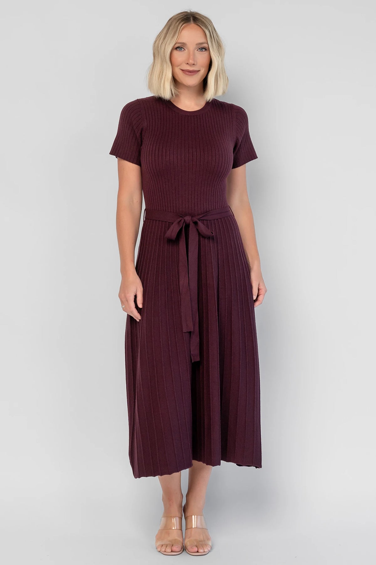 Jessamine Midi Dress in Dark Plum with a ribbed sweater knit, crew neckline, waist belt, and pleated midi skirt.