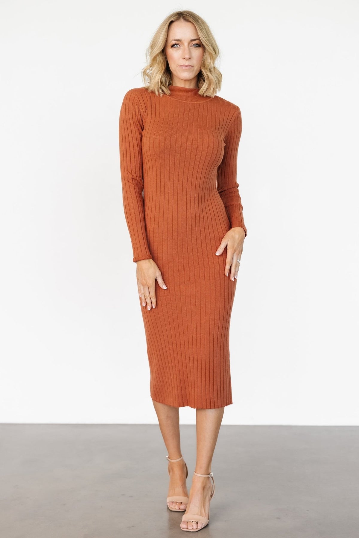 Side profile of Jill Ribbed Midi Dress in spice, highlighting body-skimming fit, mid-calf length, and the fabric's wide-rib texture with subtle stretch.