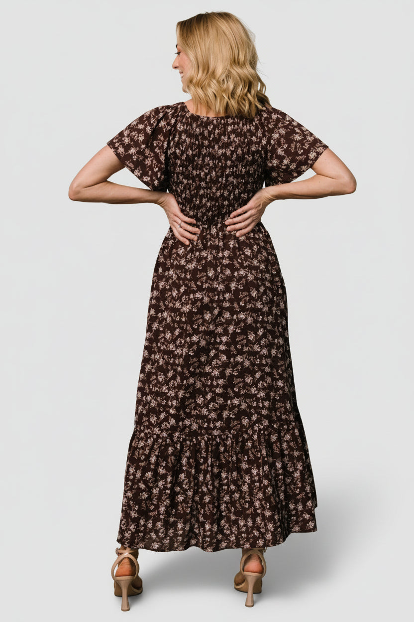 Back view of the clove floral Joanie dress showing the full skirt, back seam detail and overall midi length on model.