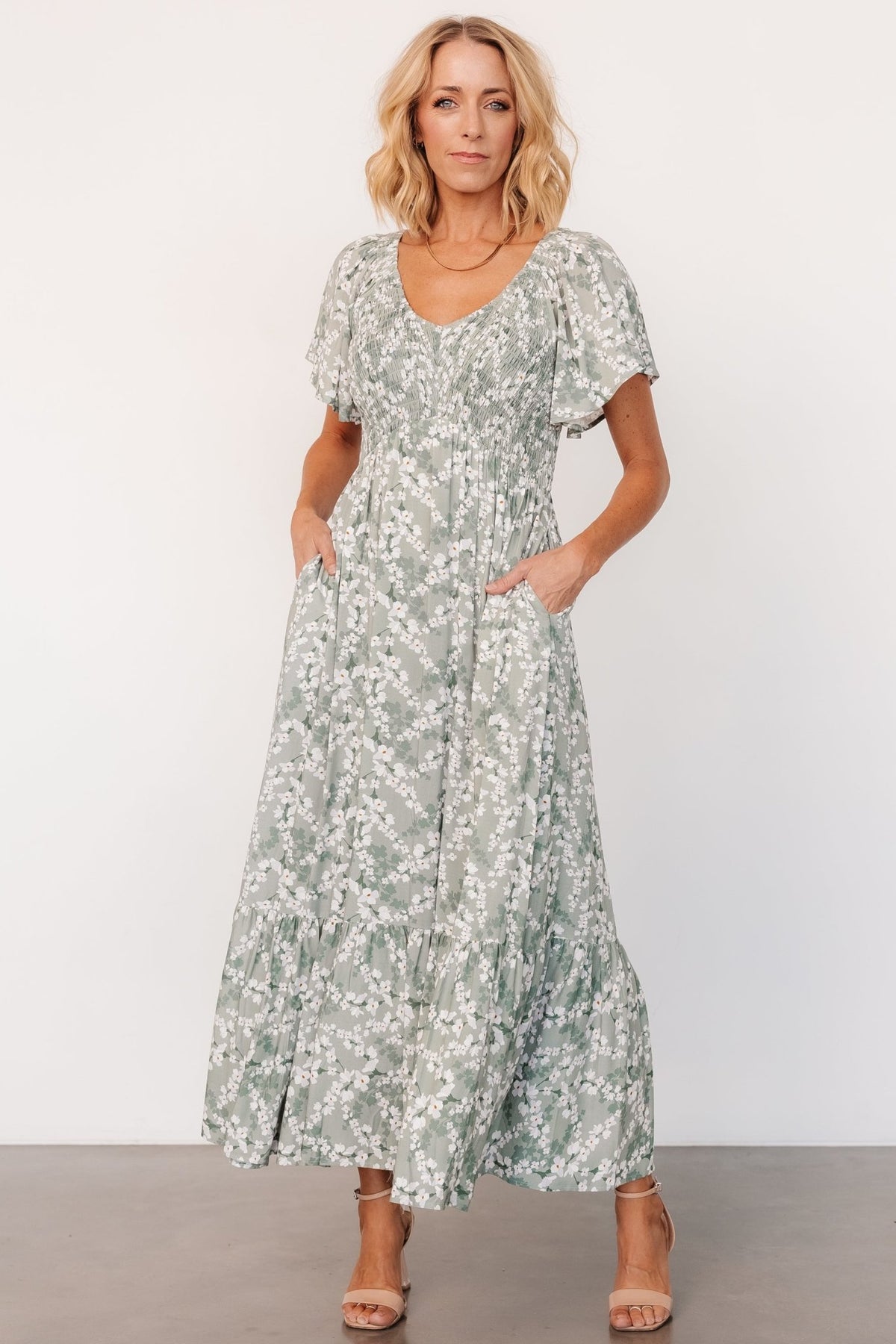 Full-length front view of Joanie Smocked Midi Dress in sage and off-white floral on model, showing overall fit and length.