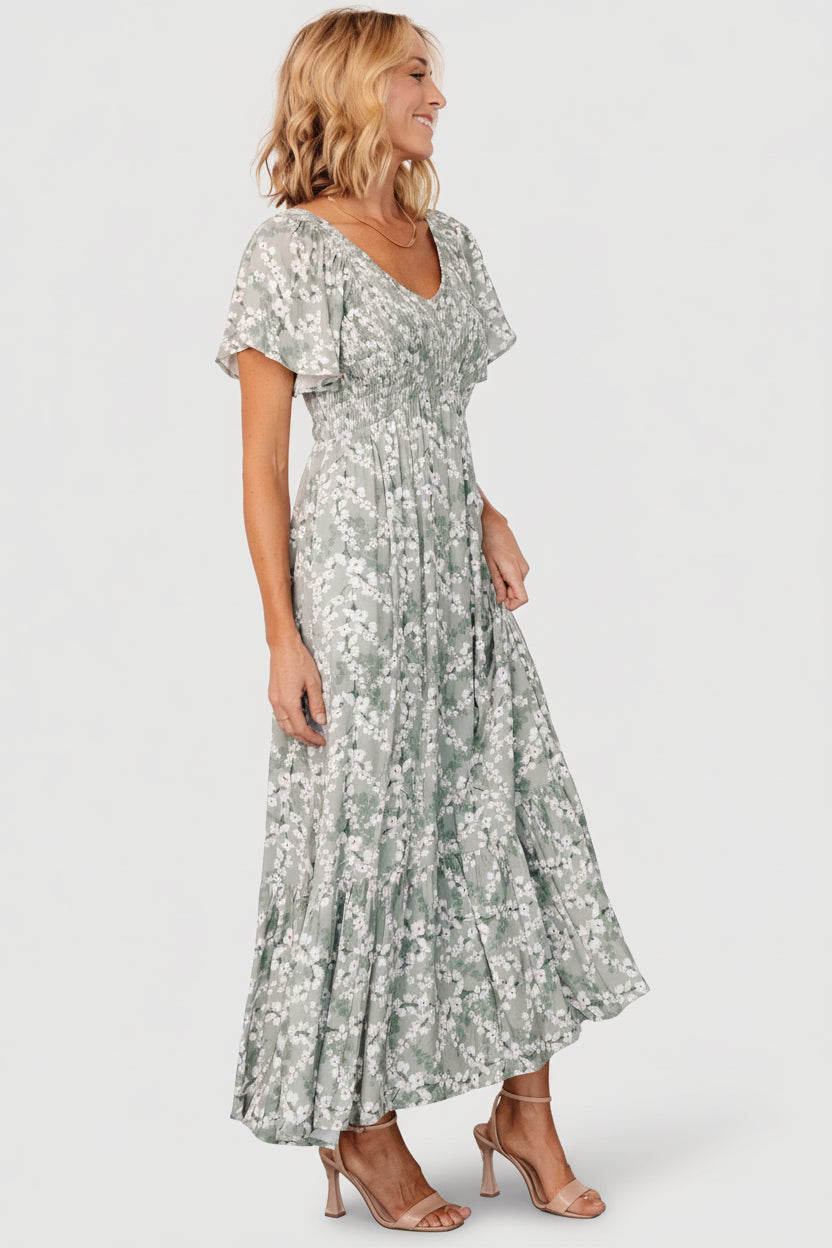 Detail image showing hidden side pocket and the lightweight rayon drape on the Joanie Smocked Midi Dress in sage floral.
