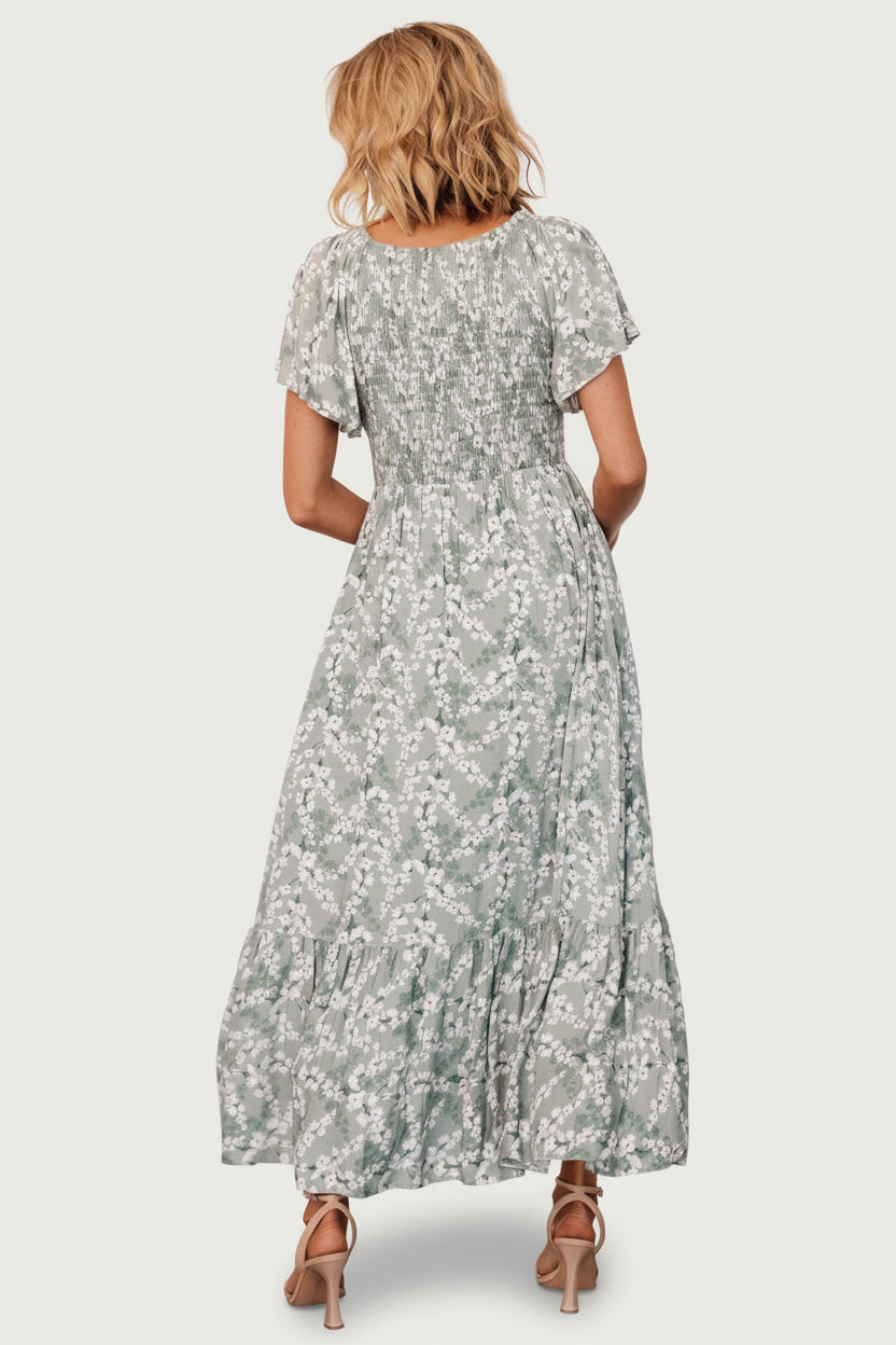 Back view of the Joanie Smocked Midi Dress showing relaxed fit, single-tier skirt, and sage floral pattern across the fabric.