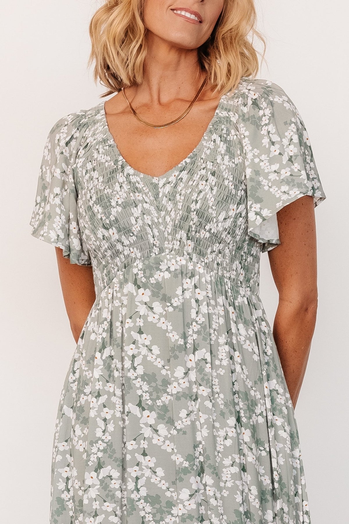 Side view of Joanie Smocked Midi Dress in sage and off-white floral, highlighting the empire waist and relaxed silhouette.