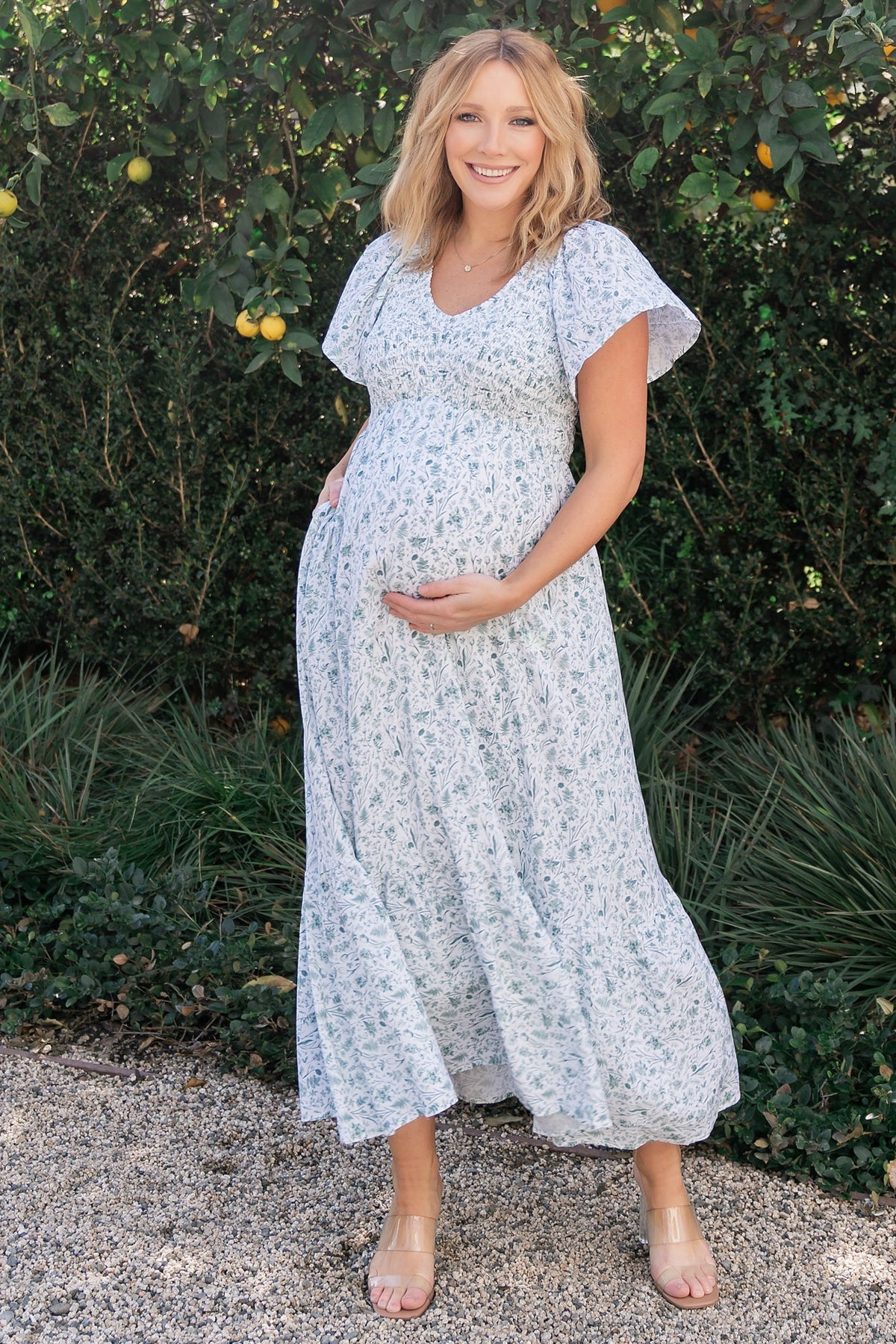 Detail shot showing hidden side pocket and drape of the rayon skirt with off-white base and dusty sage floral motif.
