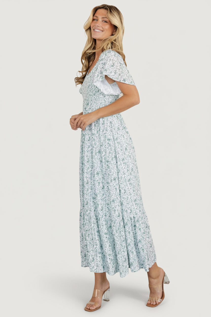 Side-angle of Joanie dress displaying flutter sleeve with shoulder smocking and the relaxed silhouette over the hip.