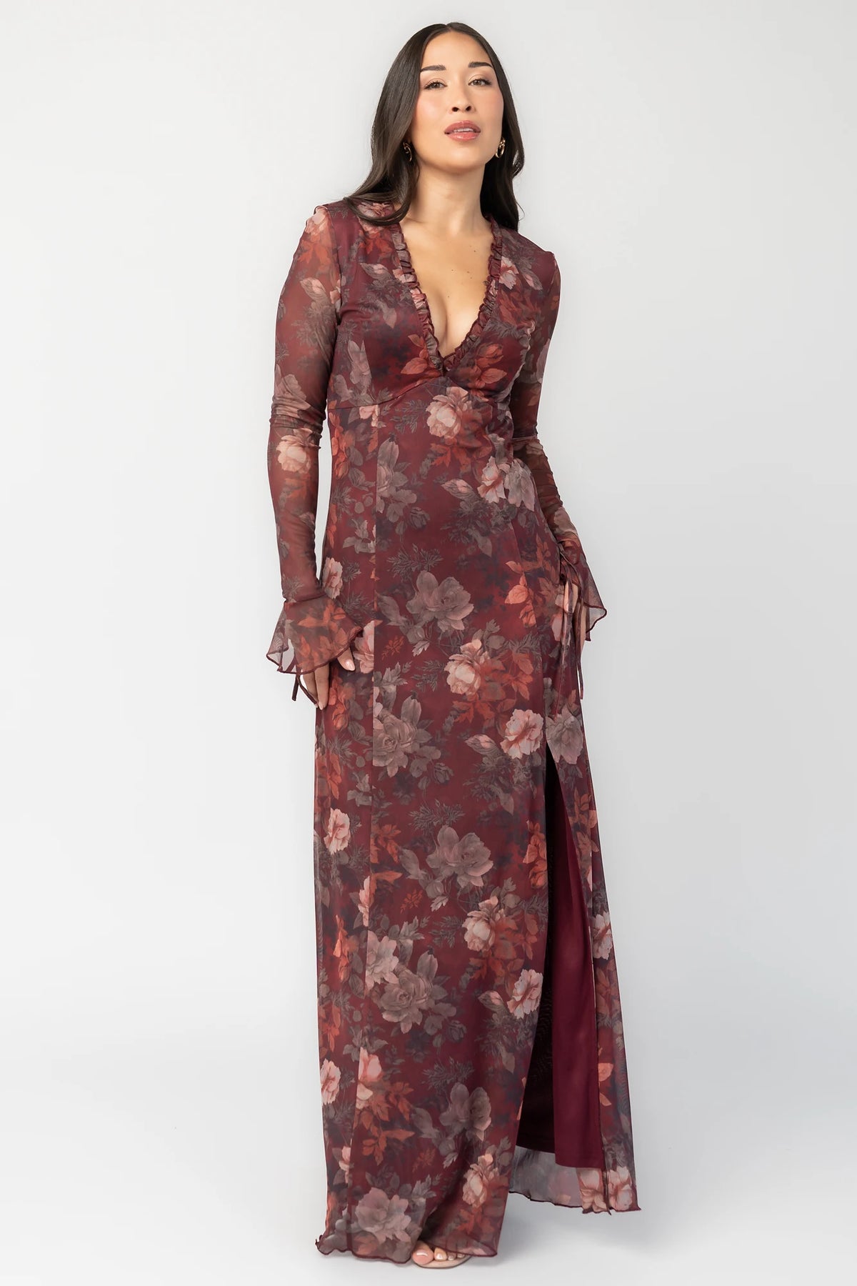 Julietta Maxi Dress in Mahogany Rose Floral with plunging V-neck, sheer long sleeves, ruffle trim, and leg slit.